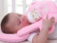 Image of a baby using a self-feeding pillow